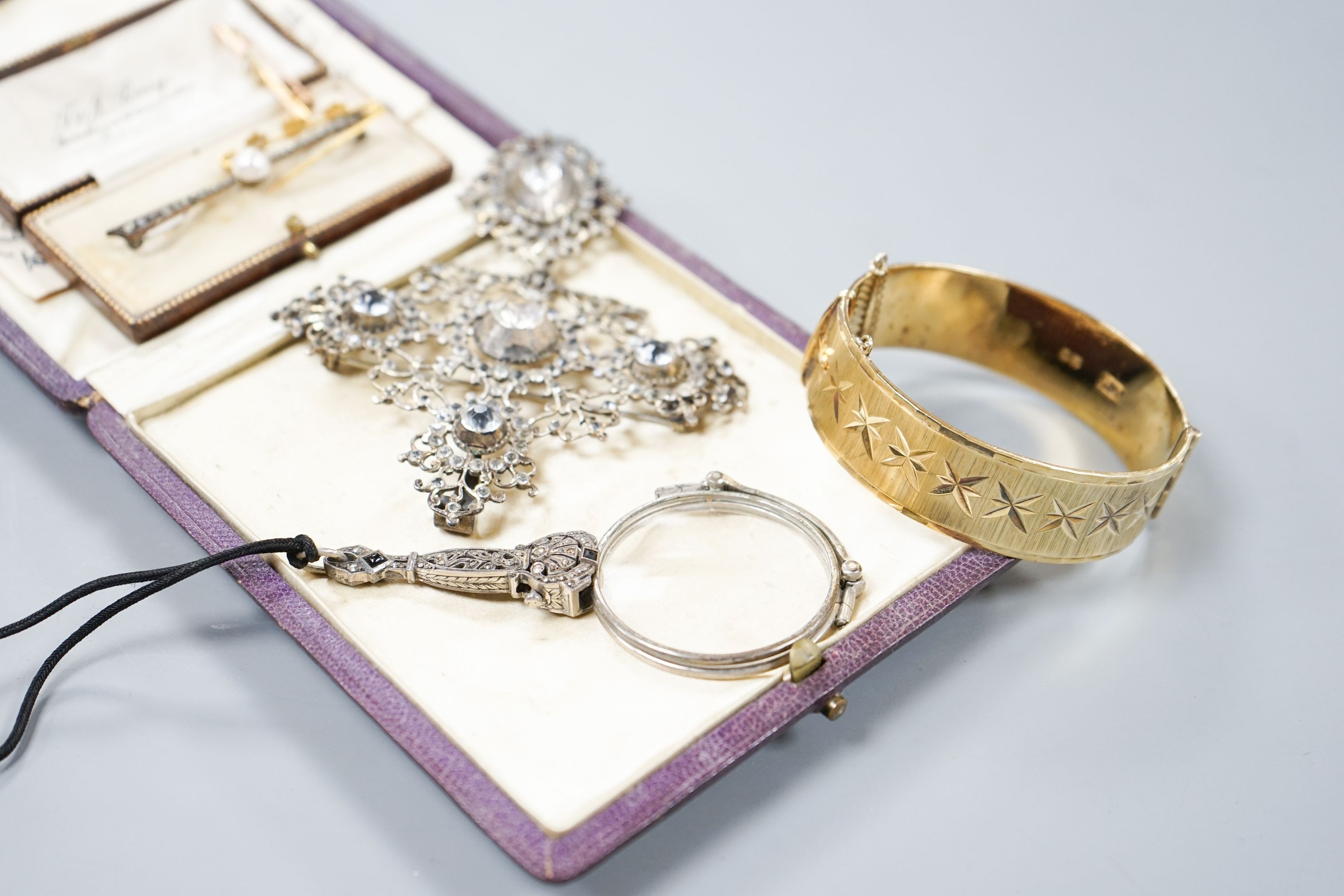 A white metal and paste set drop pendant, 10.7cm, a modern silver gilt bangle, a 9ct gold bar brooch, two other brooches and a marcasite set lorgnettes.